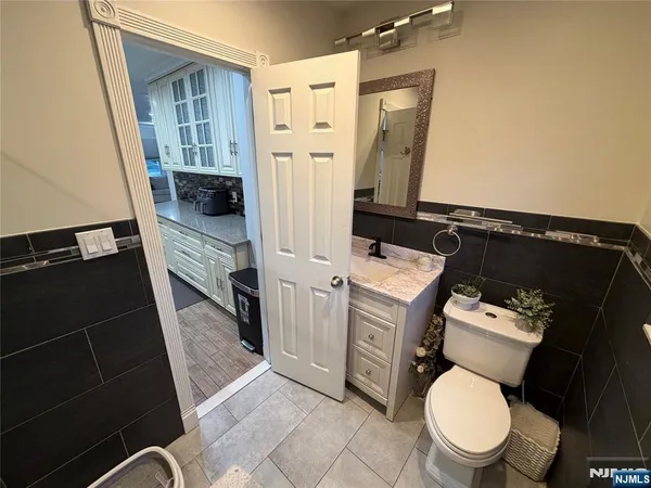 a bathroom with a granite countertop toilet sink and mirror
