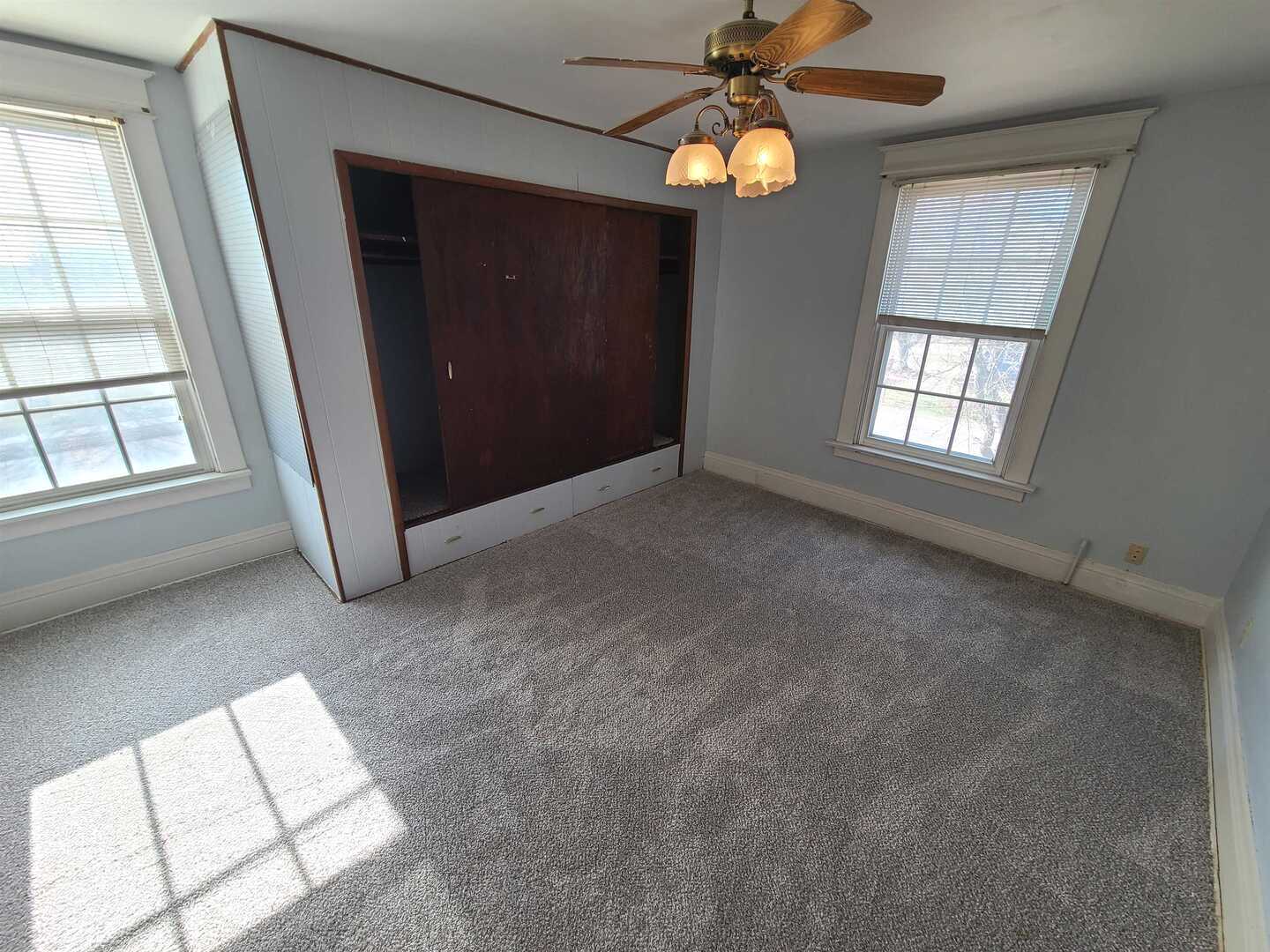 423 South Grove Street Walcott, IA 52773 - Photo 21 of 30 an empty room with windows and chandelier fan