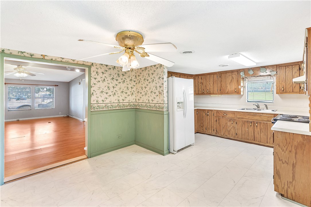 1004 Wiles Road Anderson, SC 29625 - Photo 10 of 26 A well-lit kitchen with natural wood cabinetry and a view into a spacious adjacent room.