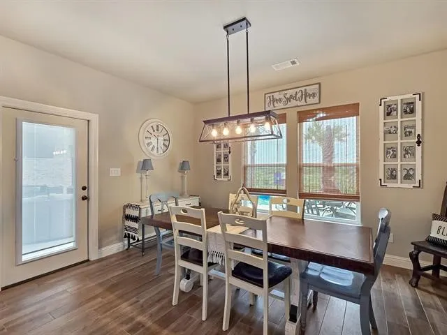a view of a hallway with wooden floor and a bathroom