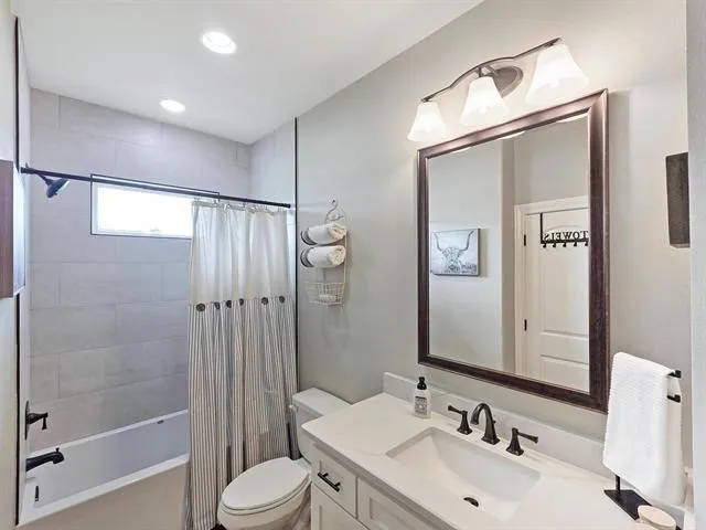 a bedroom with a large bed and a flat tv screen on dresser