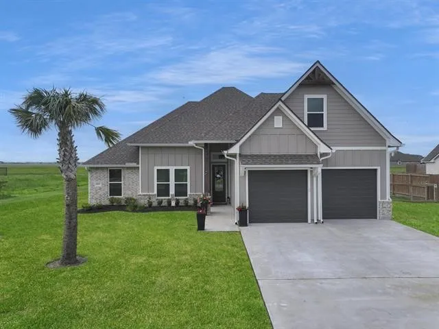 a front view of a house with a garden and yard