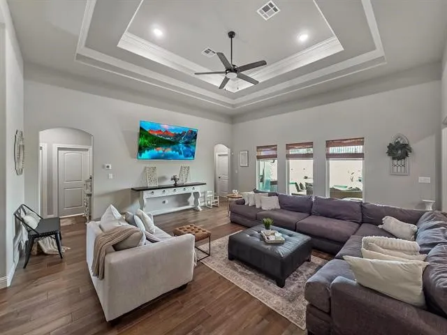 a living room with furniture a ceiling fan and a window