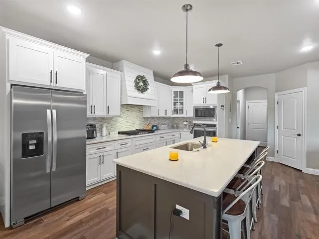 a kitchen with a sink a stove and cabinets