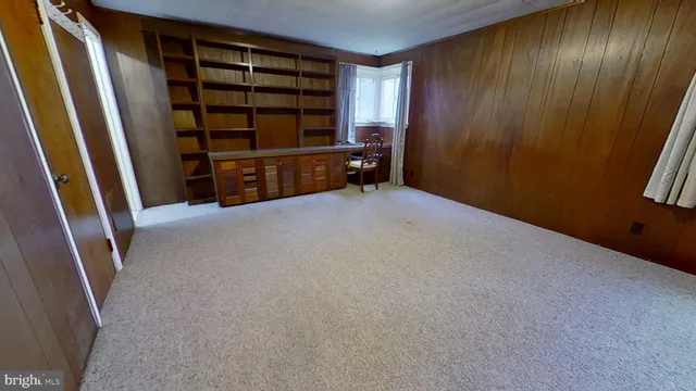 a view of an empty room with furniture and staircase