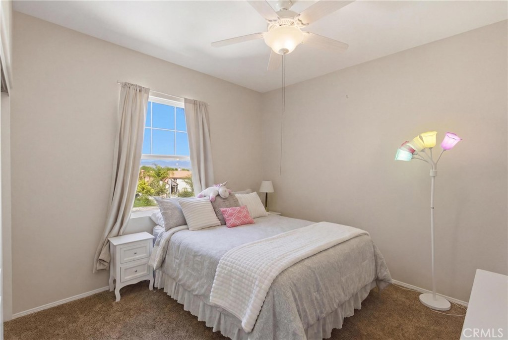 25120 Southwind Court Stevenson Ranch, CA 91381 - Photo 25 of 41 a bedroom with a bed and a chandelier