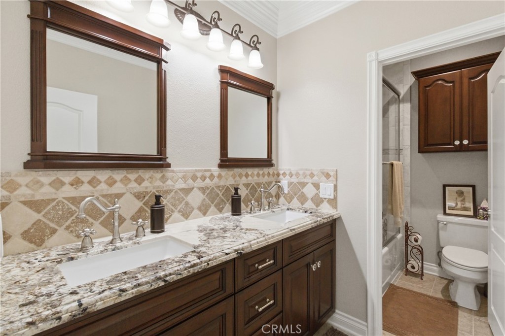 25120 Southwind Court Stevenson Ranch, CA 91381 - Photo 28 of 41 a bathroom with a granite countertop sink and a mirror