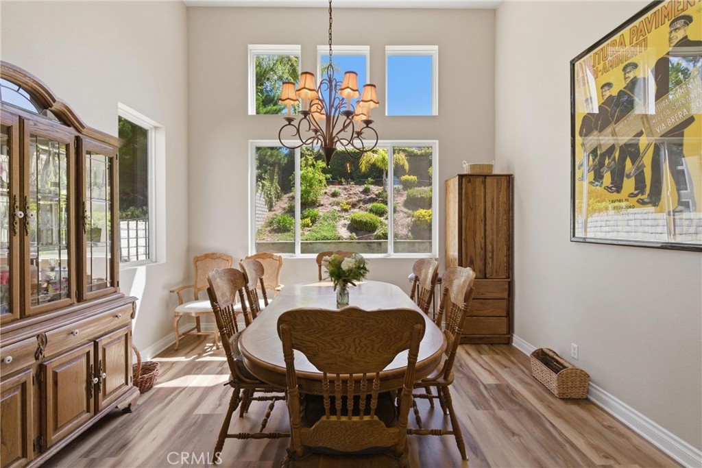 25120 Southwind Court Stevenson Ranch, CA 91381 - Photo 6 of 41 a view of a dining room with furniture a chandelier and wooden floor