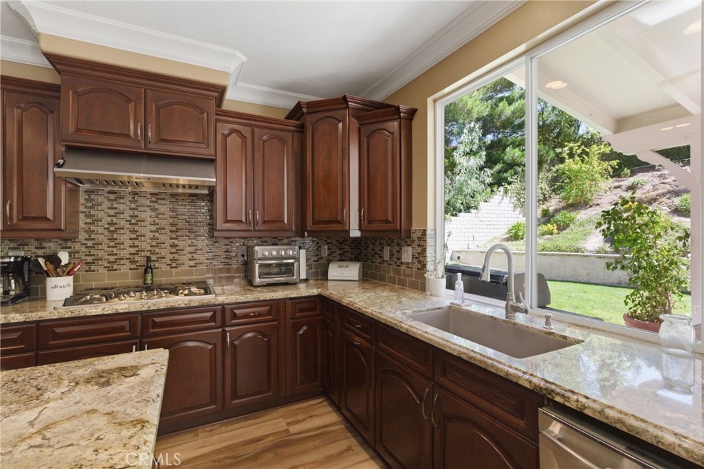 25120 Southwind Court Stevenson Ranch, CA 91381 - Photo 8 of 41 a kitchen with stainless steel appliances granite countertop wooden cabinets and a counter top space