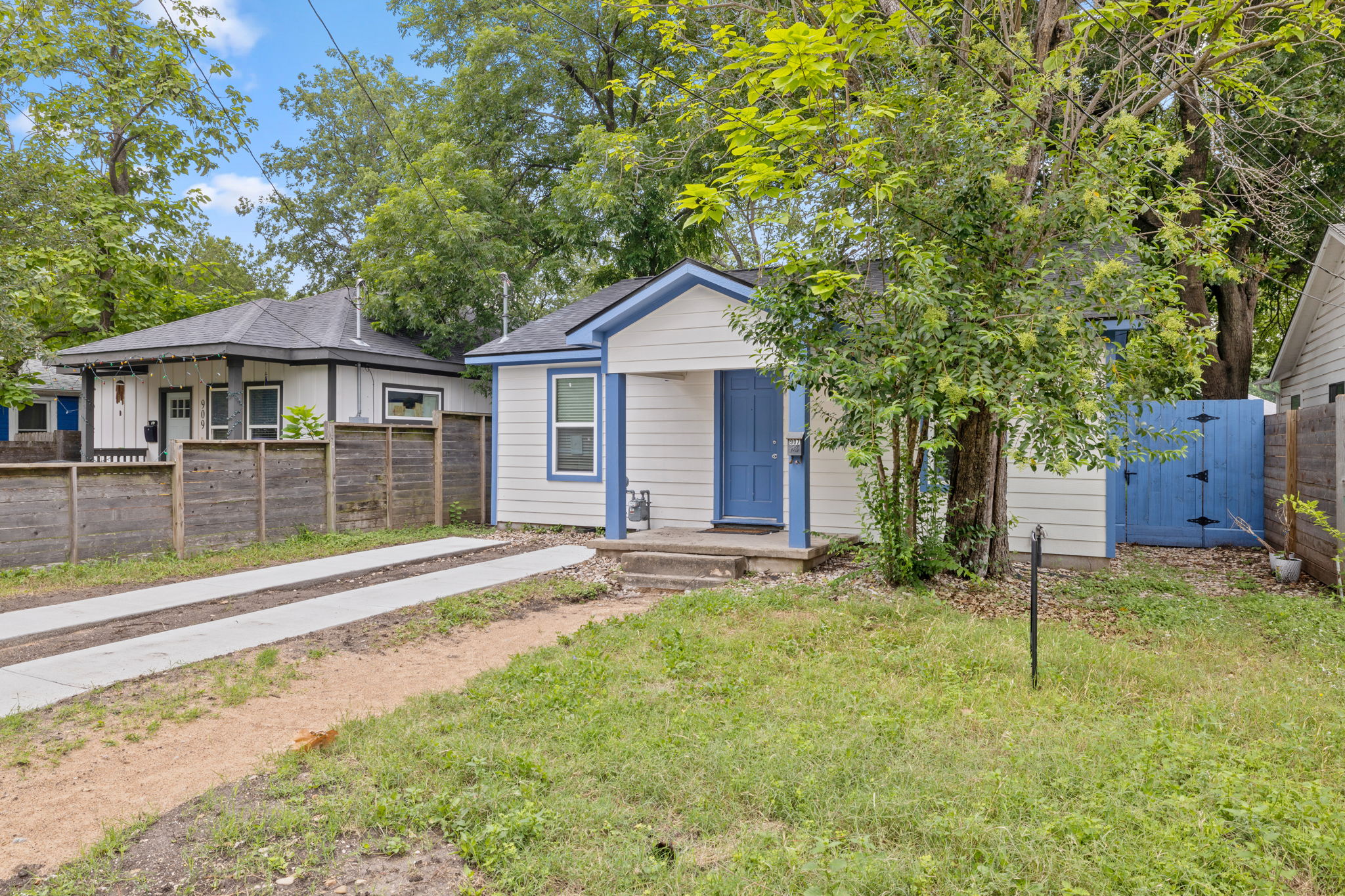 907 East 53rd Street Austin, TX 78751 - Photo 2 of 36 A charming cottage facade, highlighted by a vibrant blue door, offers inviting curb appeal.