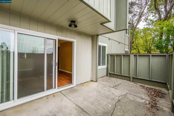 a view of backyard with large window and wooden fence