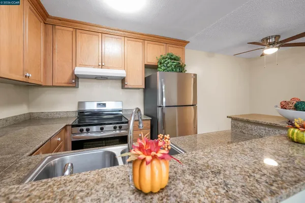 a kitchen with a refrigerator sink and cabinets