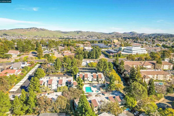 an aerial view of residential building with parking and city view