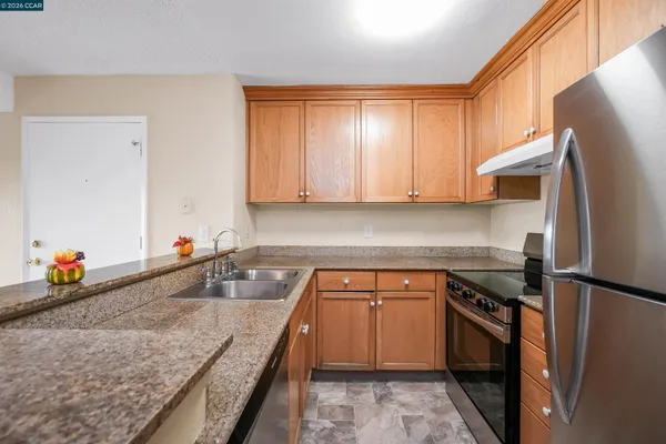 a kitchen with stainless steel appliances granite countertop a sink stove and refrigerator