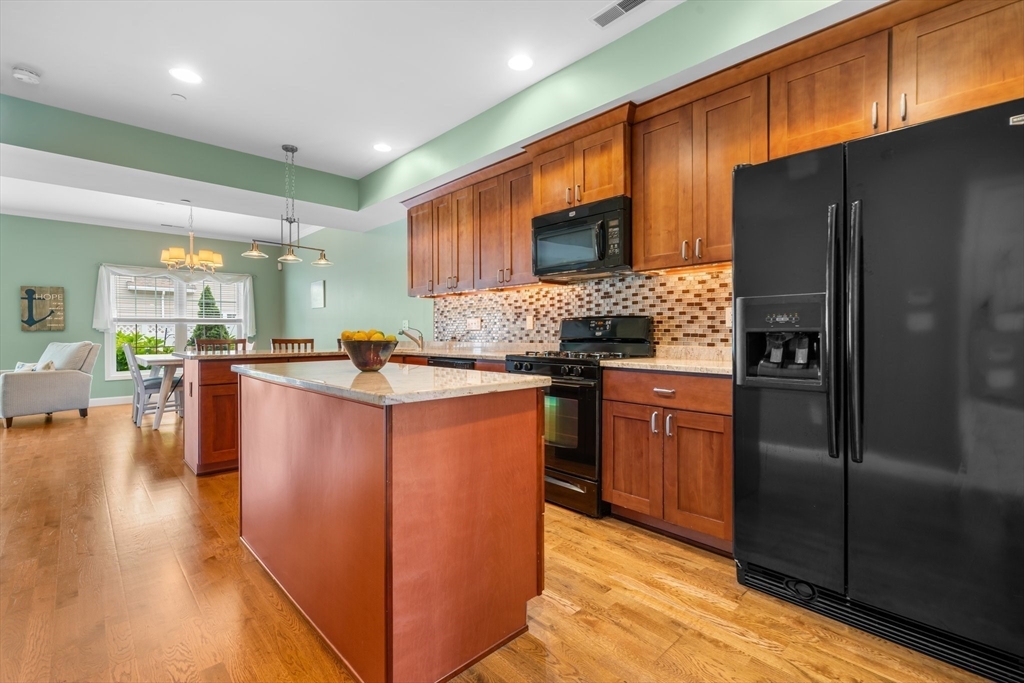 170 Beach Road, Unit 40 Salisbury, MA 01952 - Photo 12 of 32 a kitchen with stainless steel appliances granite countertop a refrigerator a stove a sink a oven with wooden cabinets and floor
