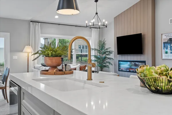 a living room with furniture a flat screen tv and a chandelier