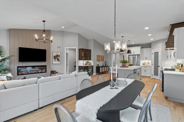 a living room with furniture a flat screen tv and kitchen view