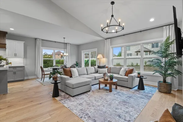 a living room with furniture potted plant and a large window