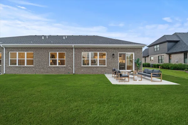 a view of a house with backyard and sitting area