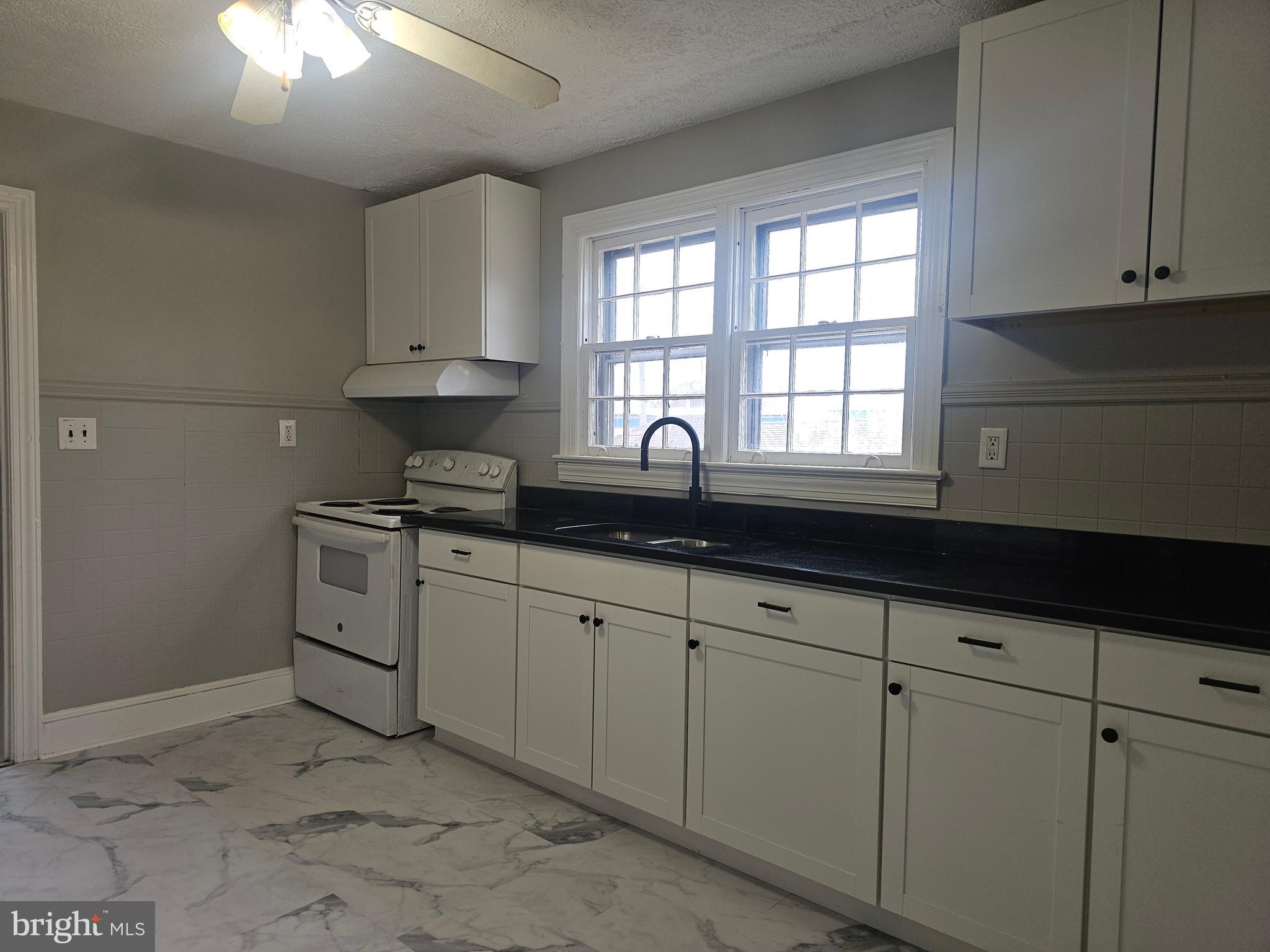 1431 Warrenton Road Fredericksburg, VA 22406 - Photo 7 of 25 a kitchen with granite countertop white cabinets and white appliances