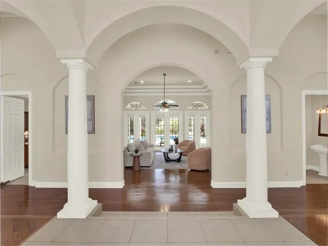 a spacious bedroom with a bed a chandelier and a window