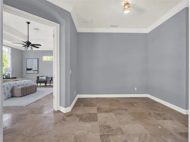 an empty room with a window and a fan