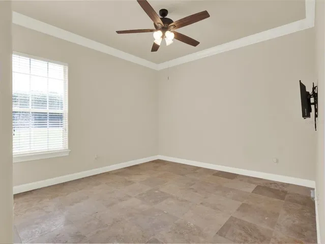 an empty room with windows and fan