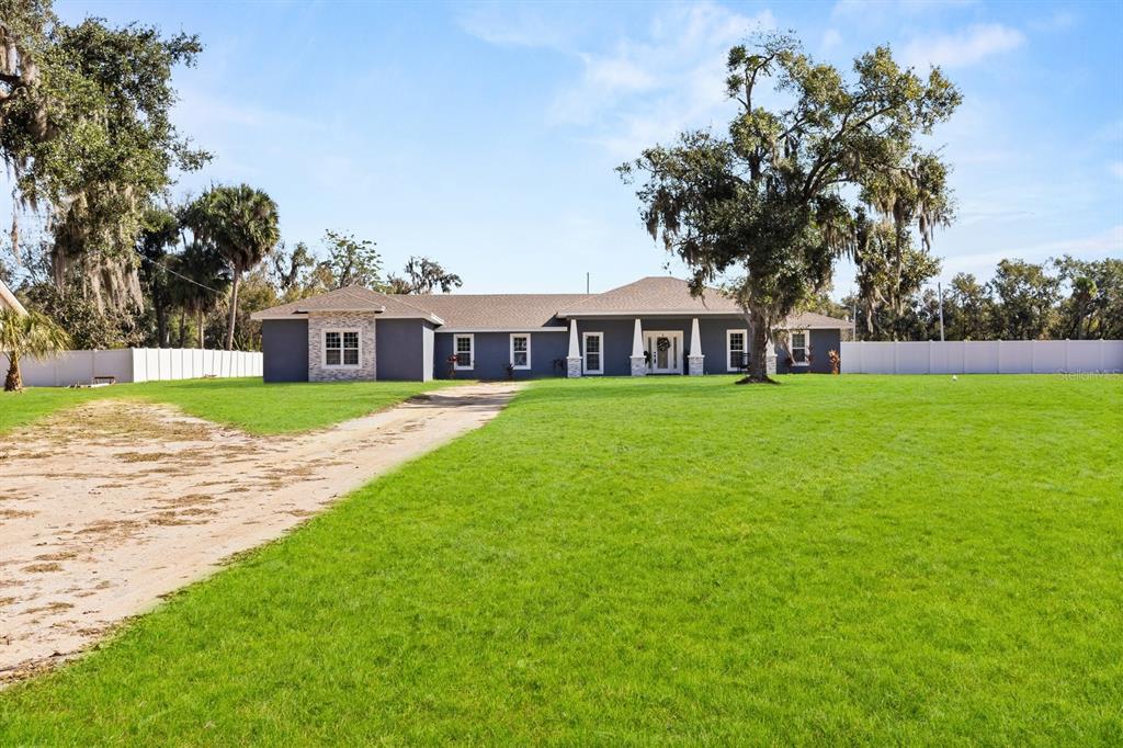 812 Chastain Road Seffner, FL 33584 - Photo 22 of 26 a view of a house with a big yard and palm trees