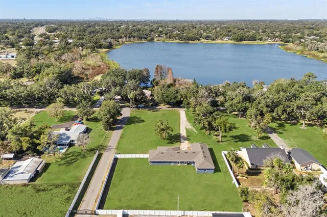 an aerial view of residential houses with outdoor space and trees