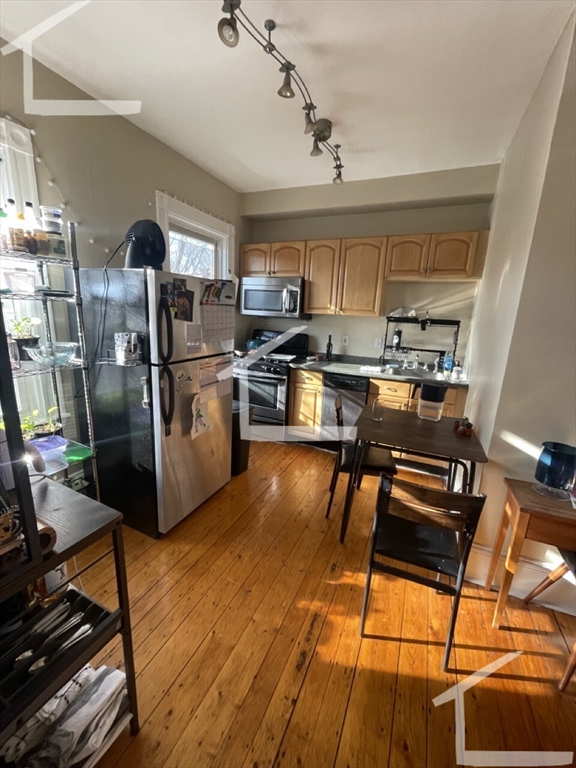 a kitchen with stainless steel appliances granite countertop a refrigerator and a stove top oven