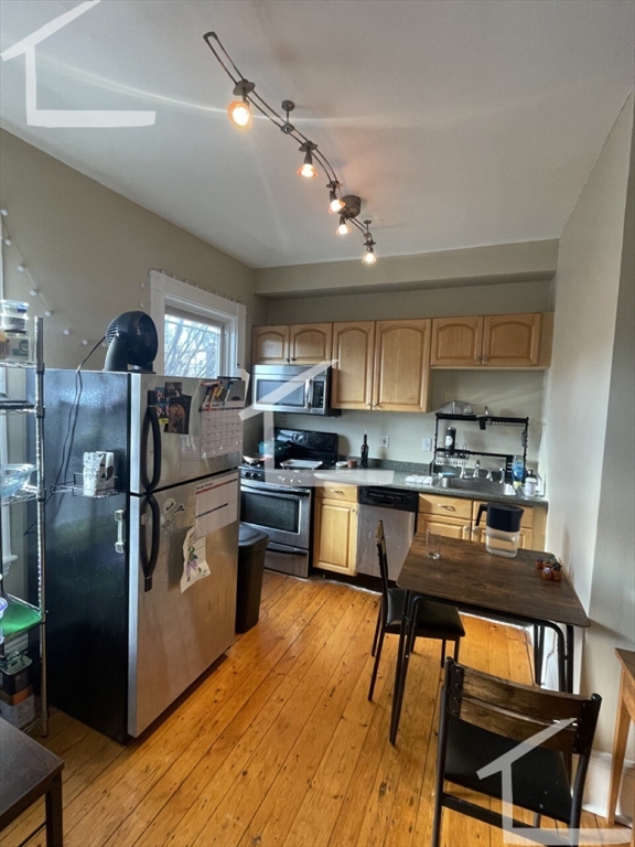 431 Faneuil Street, Unit 2A Boston, MA 02135 - Photo 6 of 8 a kitchen with stainless steel appliances granite countertop a refrigerator a sink dishwasher a stove and white cabinets with wooden floor