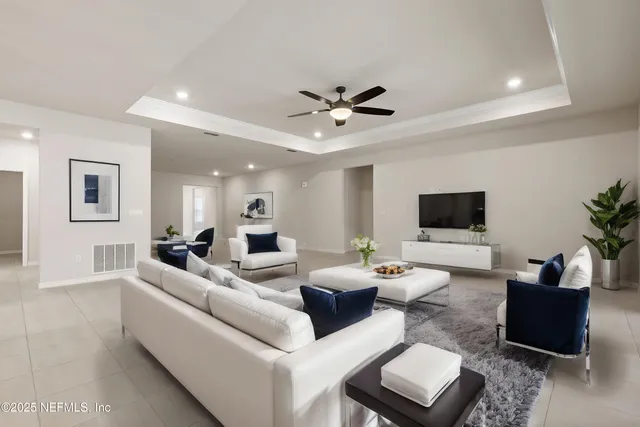 a living room with furniture a flat screen tv and a window