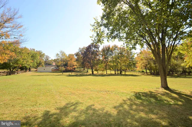 a kitchen with granite countertop a sink a stove a counter space and cabinets