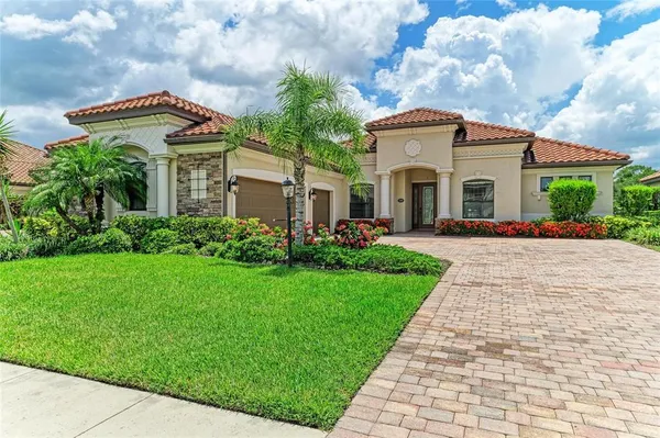 a front view of a house with a garden and plants