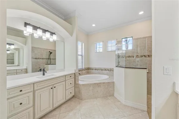 a spacious bathroom with a bathtub sink and mirror
