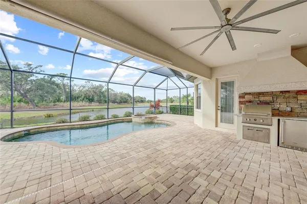 a view of a livingroom with a flat screen tv wooden floor and a large window