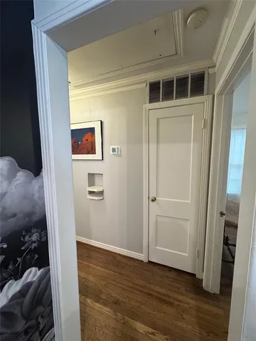 a view of empty room with wooden floor and bathroom