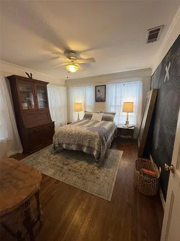 a spacious bedroom with a bed a couch and dresser