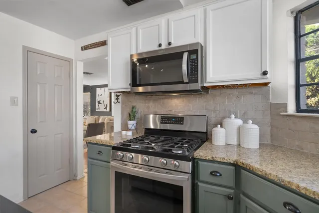 a kitchen with granite countertop a stove and a microwave