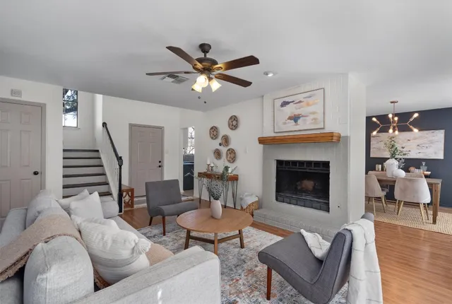 a living room with furniture a fireplace and wooden floor