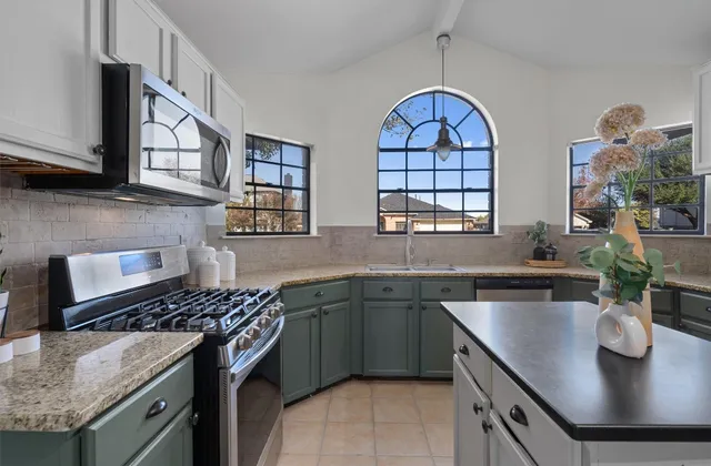 a kitchen with stainless steel appliances granite countertop a sink stove and cabinets