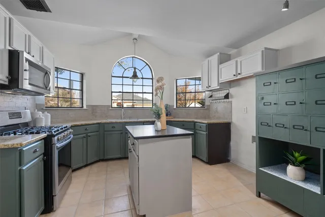 a kitchen with stainless steel appliances granite countertop a stove sink and cabinets