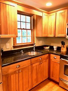 136 East Osterville Road Osterville, MA 02655 - Photo 14 of 22 a kitchen with granite countertop wooden cabinets a sink and a window