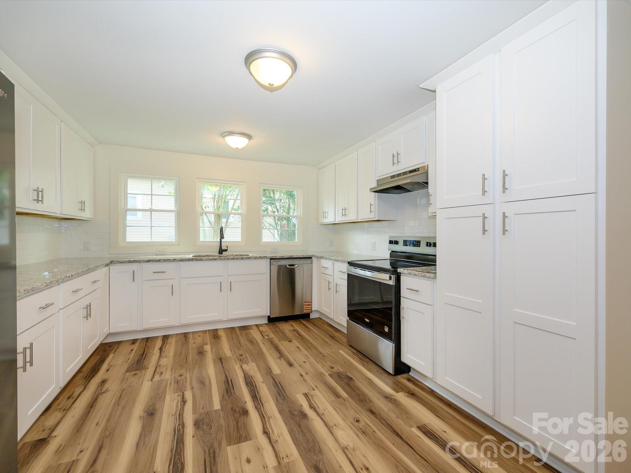 156 Hartsell School Road Southwest Concord, NC 28027 - Photo 11 of 28 a kitchen with granite countertop white cabinets and white appliances