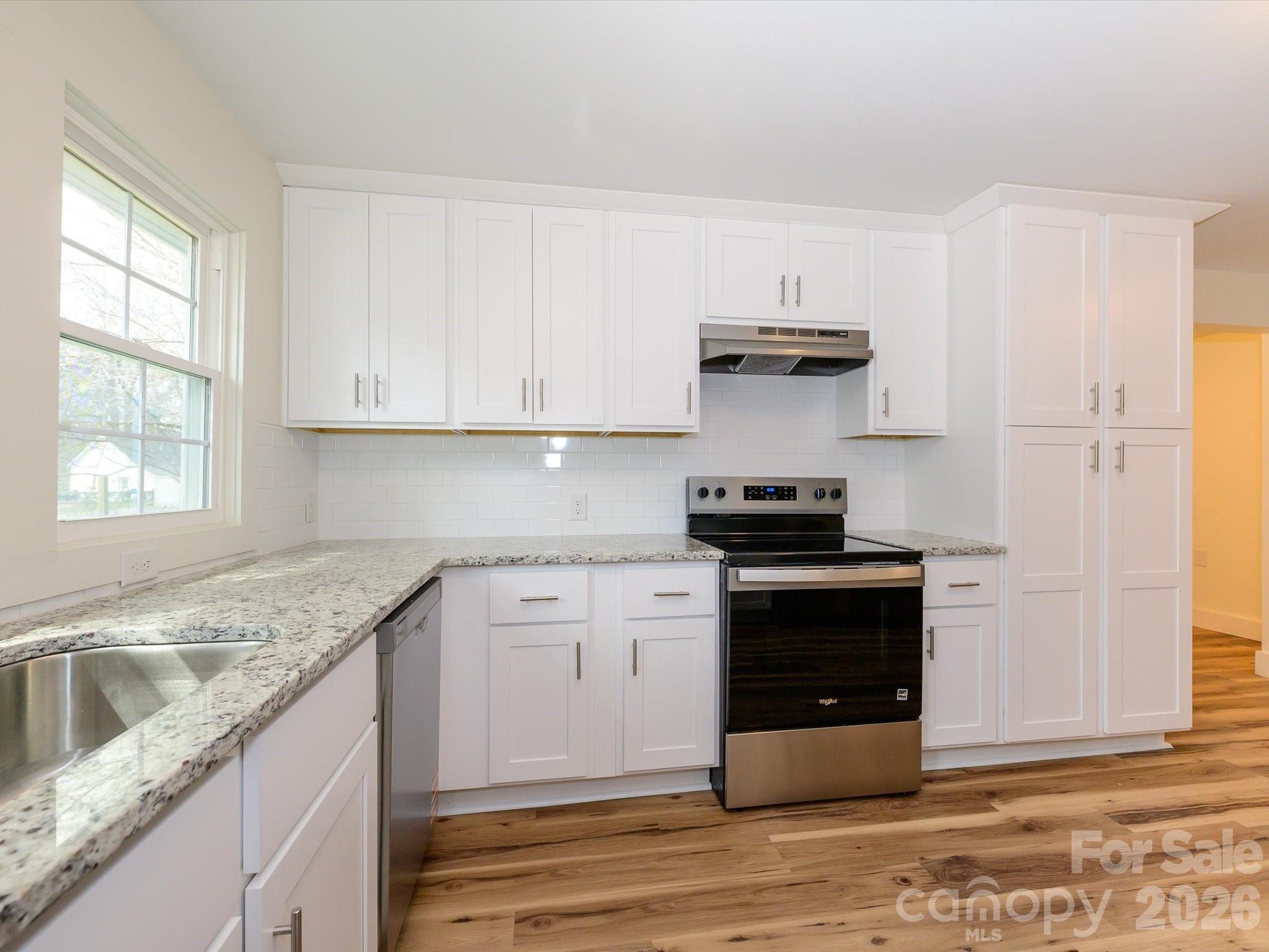 156 Hartsell School Road Southwest Concord, NC 28027 - Photo 12 of 28 a kitchen with granite countertop a stove and a sink