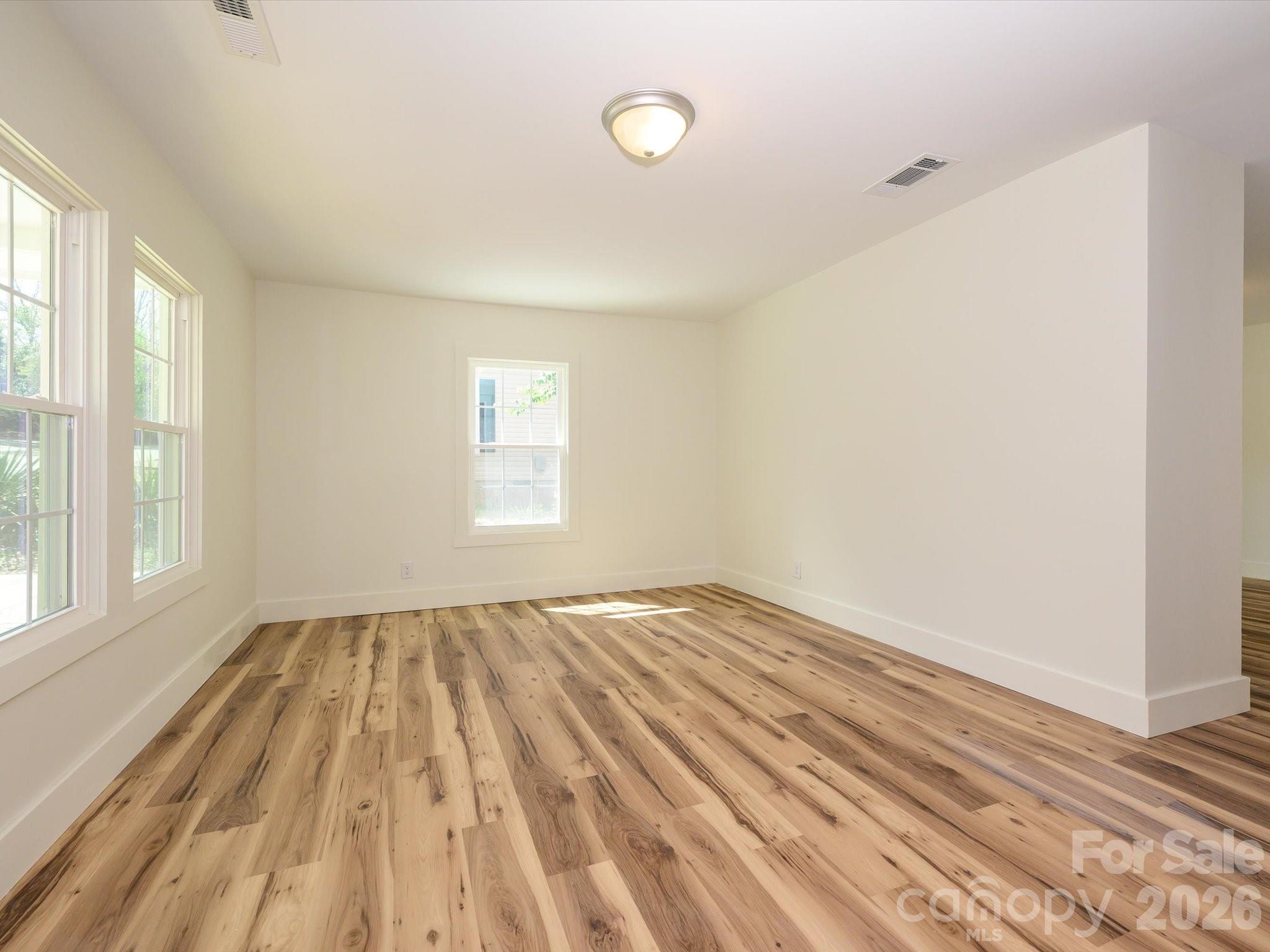 156 Hartsell School Road Southwest Concord, NC 28027 - Photo 4 of 28 a view of an empty room with wooden floor and a window