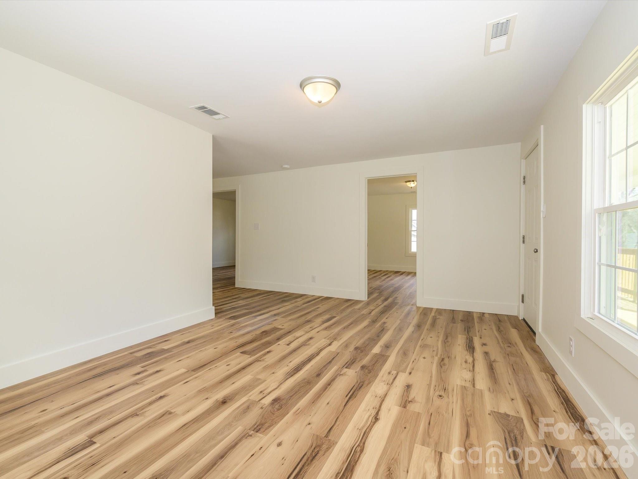156 Hartsell School Road Southwest Concord, NC 28027 - Photo 5 of 28 wooden floor in an empty room with a window