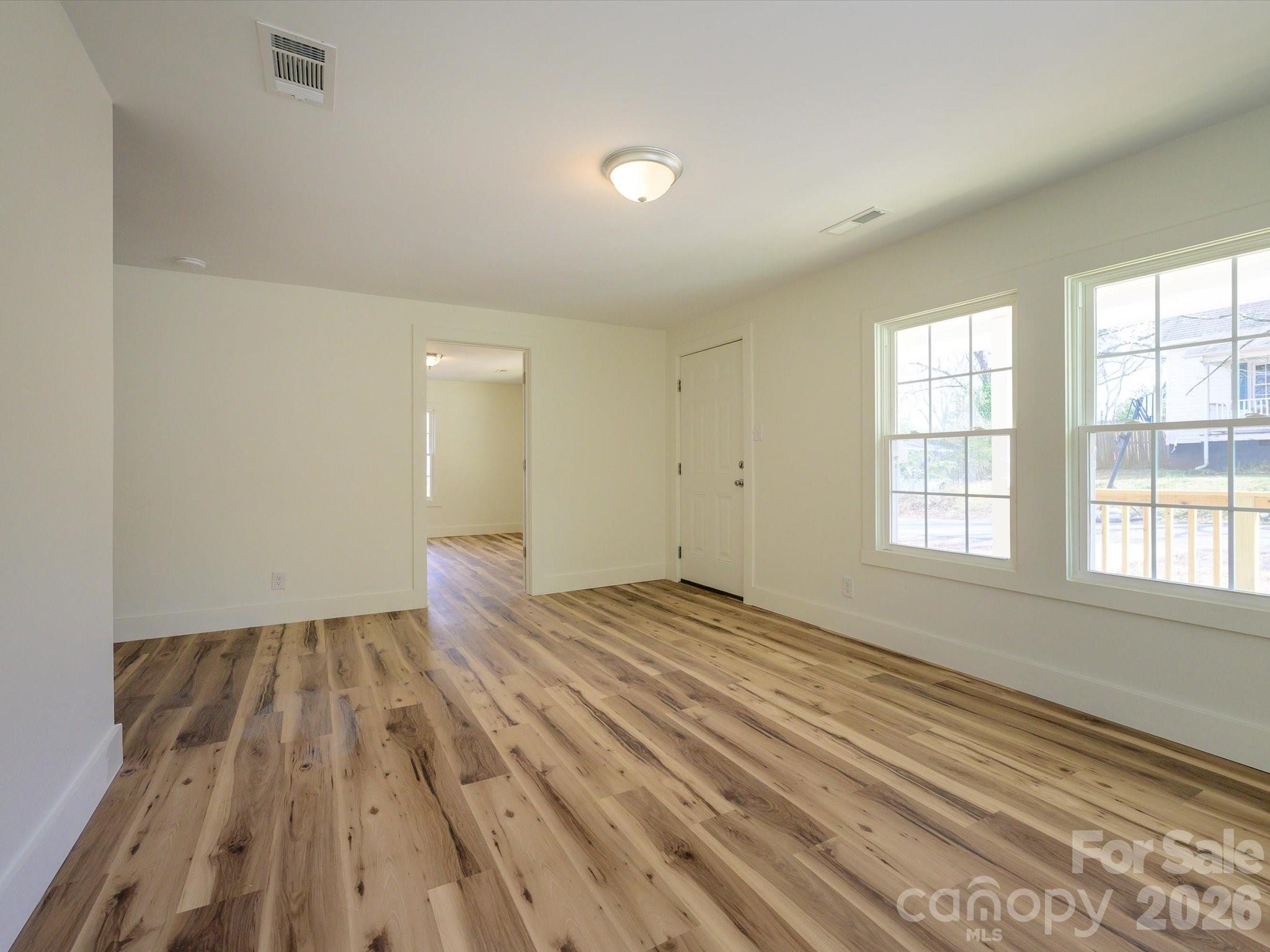 156 Hartsell School Road Southwest Concord, NC 28027 - Photo 6 of 28 a view of an empty room with wooden floor and a window