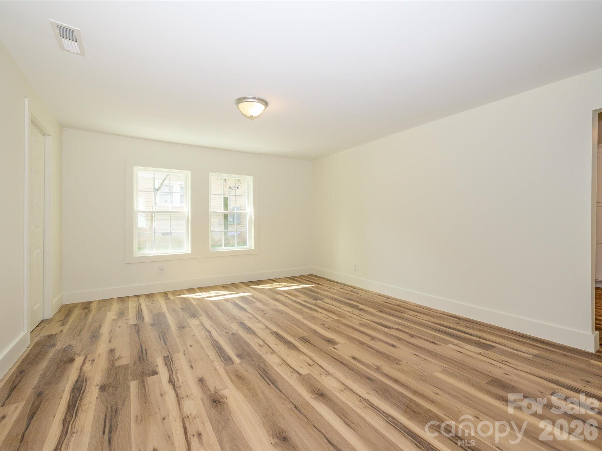 156 Hartsell School Road Southwest Concord, NC 28027 - Photo 7 of 28 a view of an empty room with wooden floor and a window