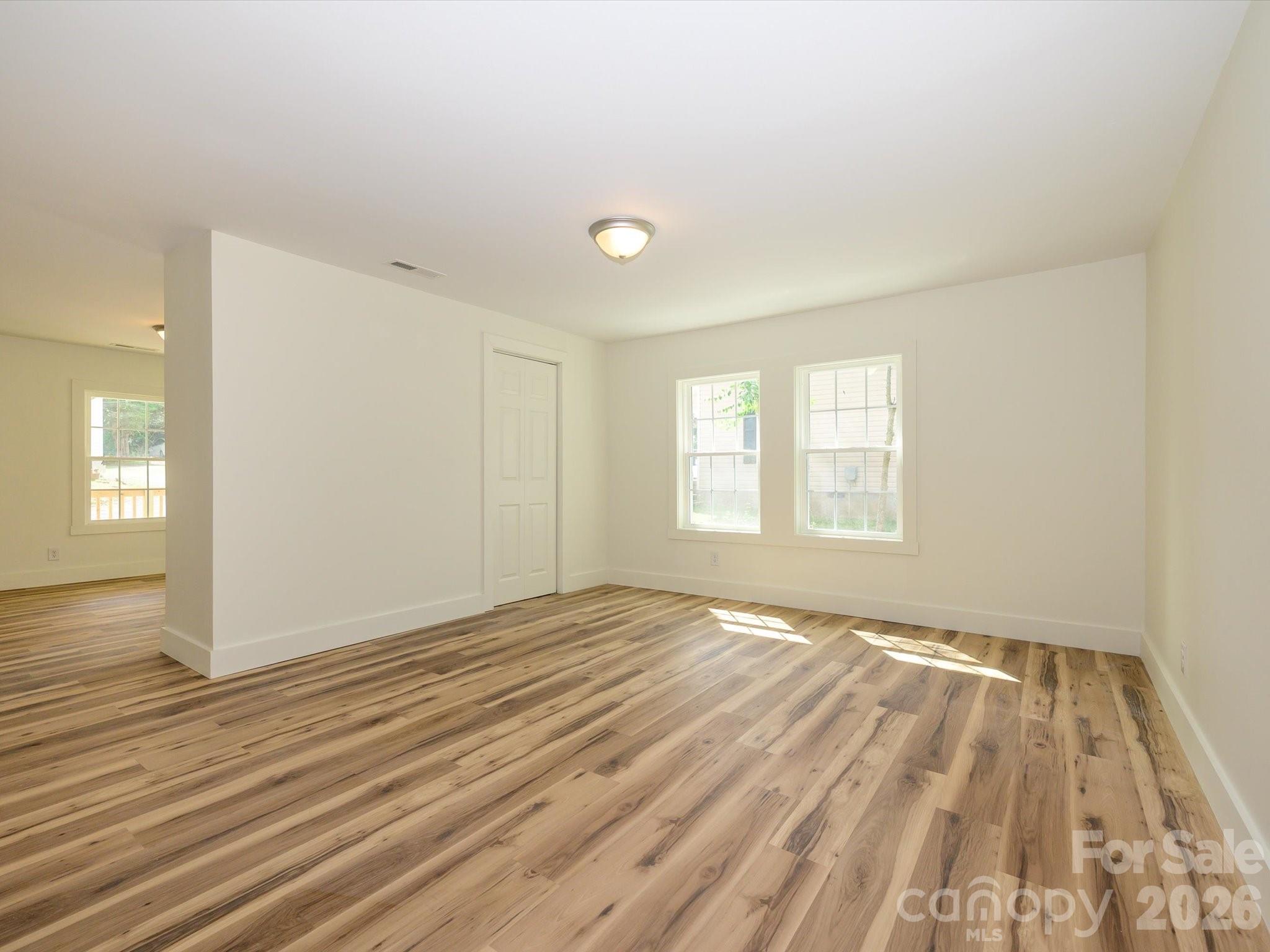 156 Hartsell School Road Southwest Concord, NC 28027 - Photo 8 of 28 a view of an empty room with wooden floor and a window